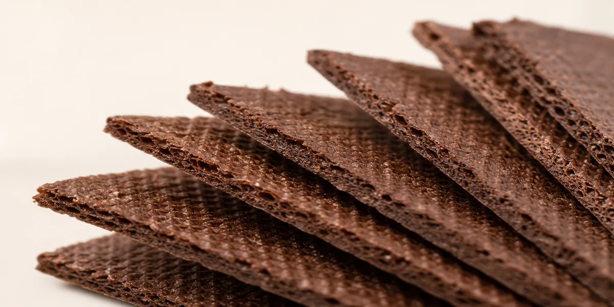 Close-up of thin dark chocolate wafer cookies showing crisp layers